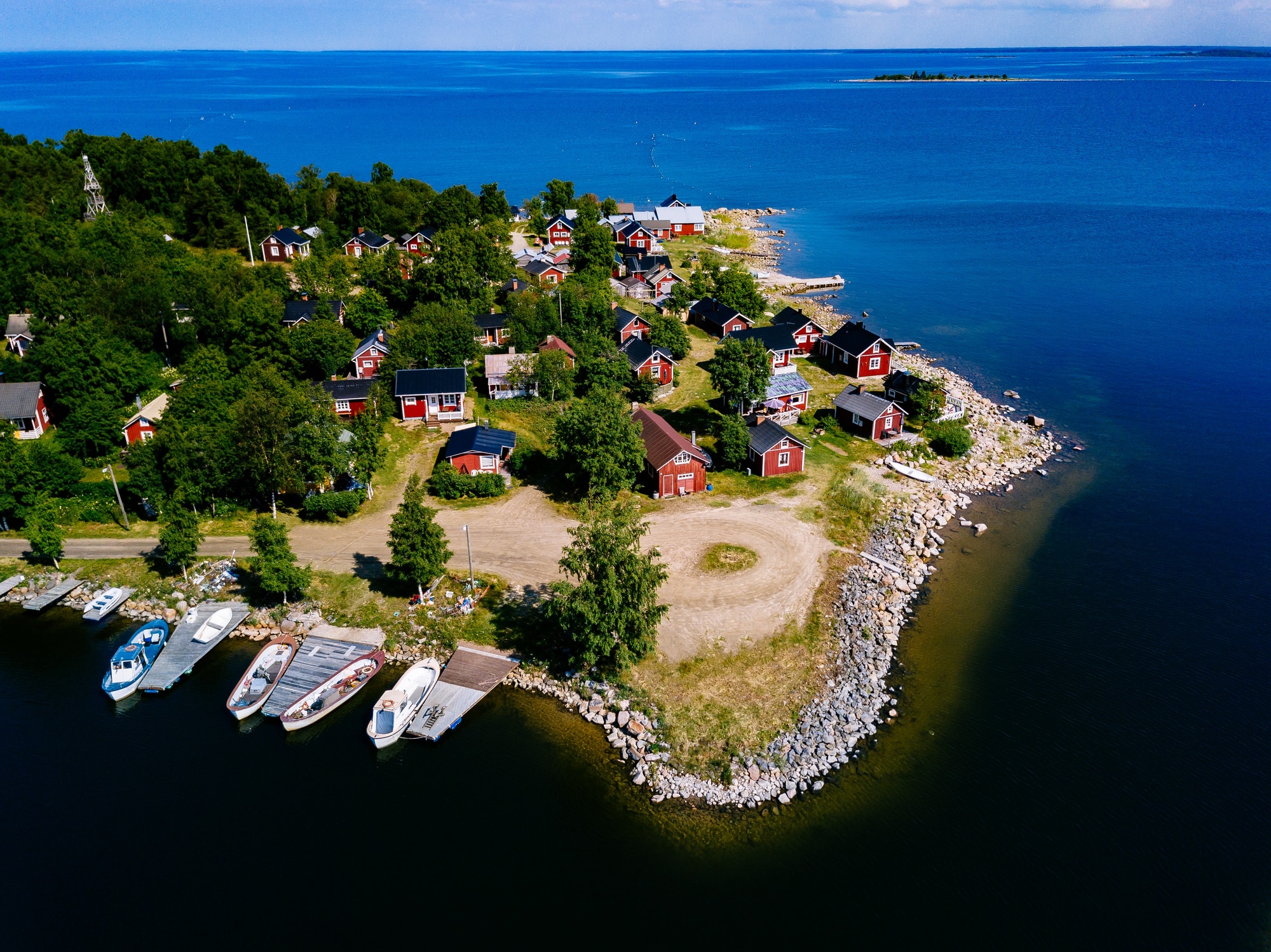 Red wooden houses on the lake or sea coast. Fishing village in Finland